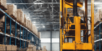 Forklift in a warehouse with stacked pallets and boxes. Global supply chain challenges. - Supply Chain News