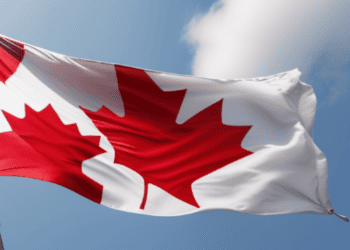 A Canadian flag, symbolizing Canada's national pride, gracefully flutters in the wind while showcasing the country's rich cultural heritage.