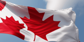 A Canadian flag, symbolizing Canada's national pride, gracefully flutters in the wind while showcasing the country's rich cultural heritage.