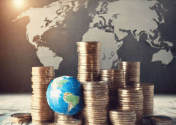 Stacks of coins and a globe, illustrating global corporate tax reforms. - Supply Chain News