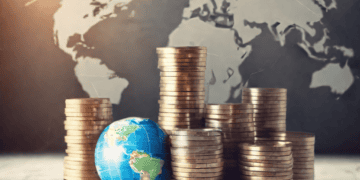 Stacks of coins and a globe, illustrating global corporate tax reforms. - Supply Chain News