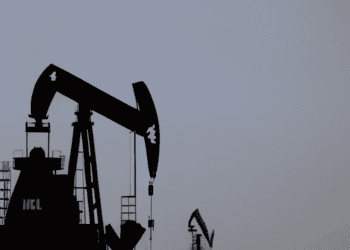 Two oil pumps in the middle of the desert extracting oil amidst an IEA forecast of a weekly increase in oil prices.