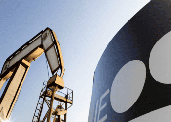 An oil pump and a sign with the word OPEC+.