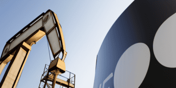 An oil pump and a sign with the word OPEC+.