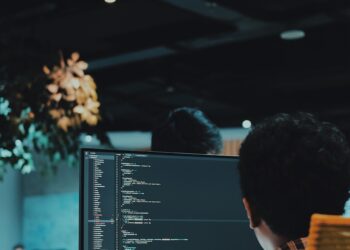 A group of people working on computers in an office, potentially vulnerable to cyberattacks.