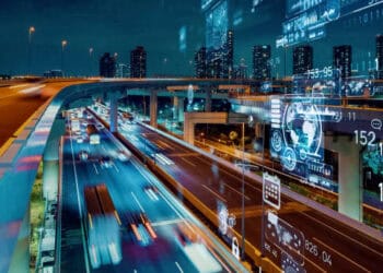 An image of a city at night with cars driving on a highway, capturing the vibrant urban life.