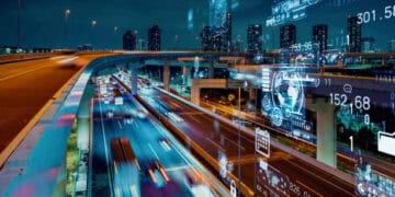 An image of a city at night with cars driving on a highway, capturing the vibrant urban life.