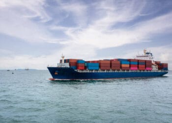 A large container ship sailing in the ocean, carrying cargo volumes bound for the Port of Oakland.