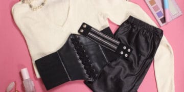 Reduction on black corset, black pants, and jewelry on a pink background.