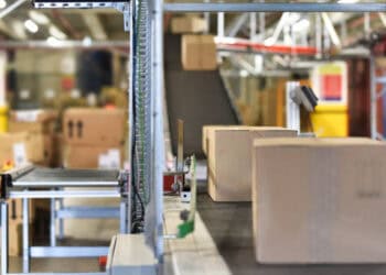 A DavidsTea warehouse utilizing in-house fulfillment, featuring a conveyor belt with boxes on it.