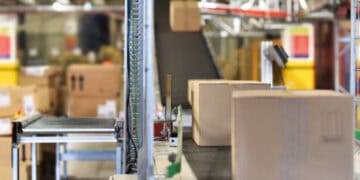 A DavidsTea warehouse utilizing in-house fulfillment, featuring a conveyor belt with boxes on it.