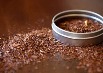 A tin of South African Rooibos Tea on a wooden table.
