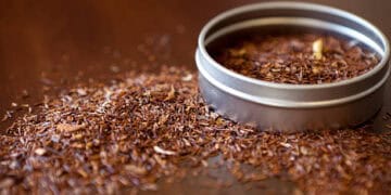 A tin of South African Rooibos Tea on a wooden table.