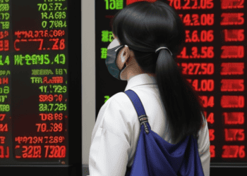 A woman wearing a face mask in front of a stock board in Tokyo.