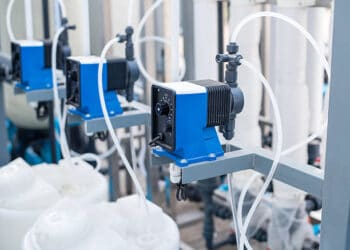 A blue and white water treatment plant with pumps and valves, part of PepsiCo's Net Water Positive initiative.