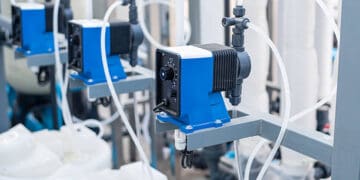 A blue and white water treatment plant with pumps and valves, part of PepsiCo's Net Water Positive initiative.