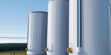 A group of white tanks in a field, representing utility ownership of energy storage in Maine.