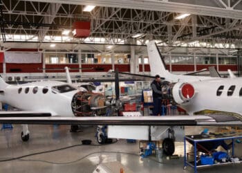 Two men working on a small airplane in a hangar while ensuring increased oversight by the FAA as per Boeing guidelines.