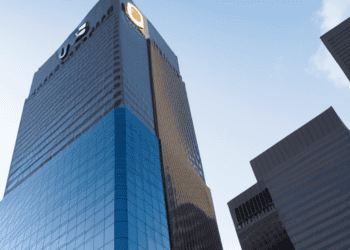 Amidst ongoing uncertainty, a towering building stands prominently with a vibrant blue sign, capturing investor concerns and reflecting the state of US regional banks.