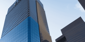 Amidst ongoing uncertainty, a towering building stands prominently with a vibrant blue sign, capturing investor concerns and reflecting the state of US regional banks.