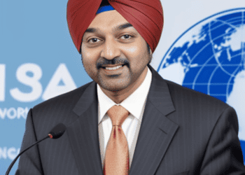 Ajay Banga, the elected President, confidently stands at the podium wearing a suit and turban.