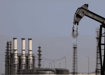 Oil pump jack operating near refinery, crude oil production. - Supply Chain News