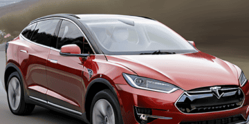 The Tesla Model X overtakes a red BYD on the road.