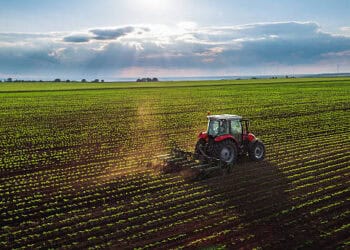 A USDA-launched aerial view of a tractor plowing a field to strengthen farming practices.