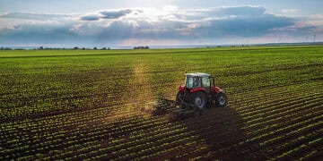 A USDA-launched aerial view of a tractor plowing a field to strengthen farming practices.
