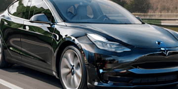 The upgraded Tesla Model 3 is driving down the road in North America.