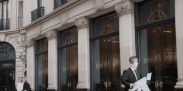 A man in a suit walks past a building, symbolizing stability in the Euro Zone economy.