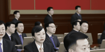 A group of people sitting at desks in front of a Chinese flag, with questions arising about the involvement of Bain & Company and Chinese authorities.