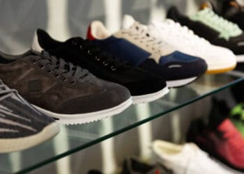 A row of Nike sneakers on a glass shelf, showcasing the company's inventory strategy to meet consumer demand.