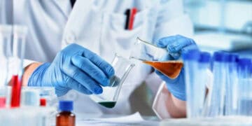 A scientist from China is working in a laboratory with a test tube, studying the impact of Taiwanese chemical imports and tariff concessions.