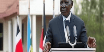 Kenyan President, Mwai Kibaki, speaks at a podium in front of flags.