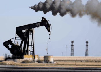 Oil pump jack emitting black smoke, indicating a decline in US crude oil production amid inflation concerns. - Supply Chain News