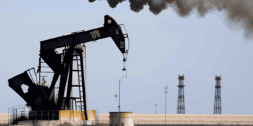 Oil pump jack emitting black smoke, indicating a decline in US crude oil production amid inflation concerns. - Supply Chain News