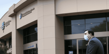 A man wearing a face mask walks in front of a building where challenges arise for depositors withdrawing funds from First Republic Bank.