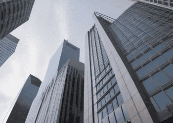 Skyscrapers rise towards a bright sky, illustrating potential economic challenges. - Supply Chain News