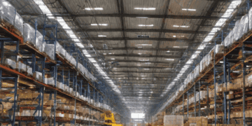 Vast warehouse interior with high shelving units stocked with boxes. Victory Group's strategic expansion. - Supply Chain News