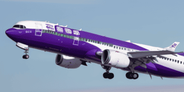 An airline facing operational challenges, despite bankruptcy, with a purple and white airplane flying in the sky.