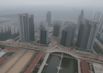 An aerial view of a city with tall buildings and a river, showcasing China's local governments and their financial challenges.