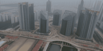 An aerial view of a city with tall buildings and a river, showcasing China's local governments and their financial challenges.