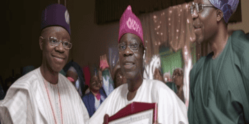 President-Elect Tinubu, along with two other men, is holding a certificate, addressing a crowd of Nigerians about recent economic reforms.