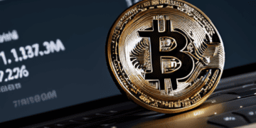 A bitcoin resting on a laptop screen, representing the vast trading volume in ETFs.