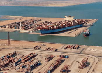 Aerial view of a large container ship at port near the Suez Canal, illustrating global supply chain challenges. - Supply Chain News