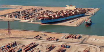 Aerial view of a large container ship at port near the Suez Canal, illustrating global supply chain challenges. - Supply Chain News