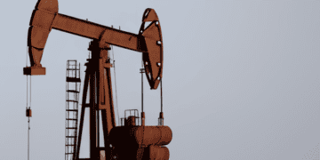 An oil pump in the middle of the desert extracting crude oil amidst the fluctuating global oil prices.