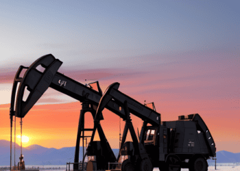 An oil pump in the desert at sunset, contributing to the ever-increasing global oil demand.