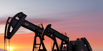 An oil pump in the desert at sunset, contributing to the ever-increasing global oil demand.